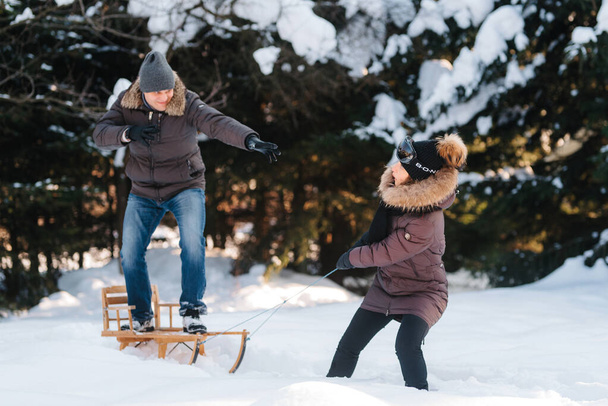 chlapec a dívka venku na zimní procházku hrát sněhové koule a sáňkování - Fotografie, Obrázek
