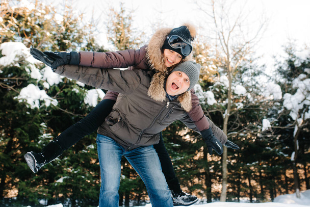 冬の散歩中の男の子と女の子は雪玉とそりで外に出て - 写真・画像