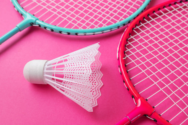 Badminton rackets en shuttlecock op een felroze achtergrond. Het concept van uitrusting voor amateursporten. Minimalisme. - Foto, afbeelding