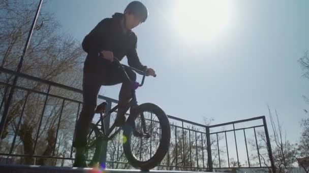 Samotný bmx jezdec v černé mikině na rampách ve skateparku - Záběry, video