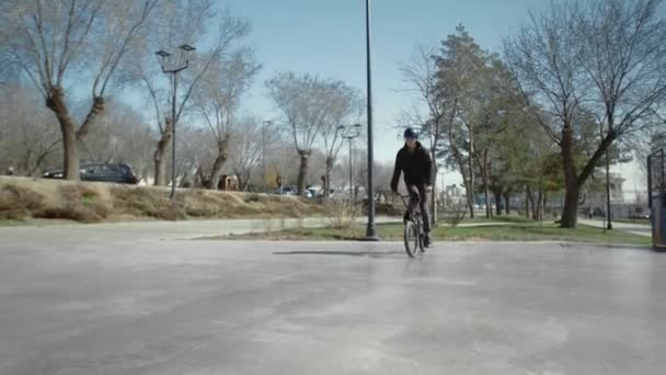 Egy fiatal BMX lovas trükköket csinál a pipával a gördeszka parkban.. - Felvétel, videó