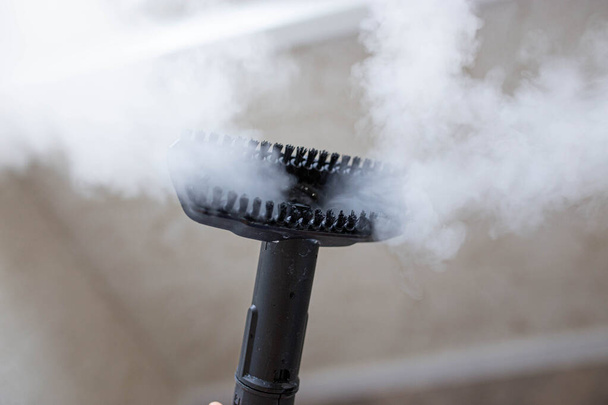 steam erupting from brush of steam cleaner for cleaning house - Foto, imagen