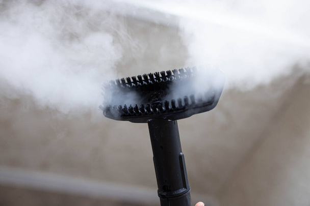 steam erupting from brush of steam cleaner for cleaning house - Valokuva, kuva
