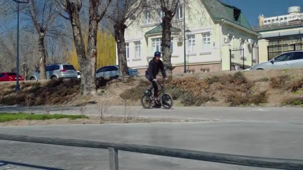 Mladý bmx jezdec skáče s rotující přes potrubí v skate parku. - Záběry, video