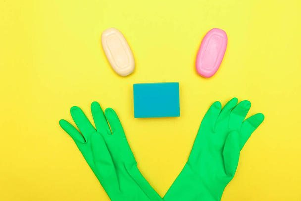 The concept of cleanliness and hygiene. The face is lined with detergents, gloves, soap and sponges. Disinfection. Space for text, flat lay. - 写真・画像