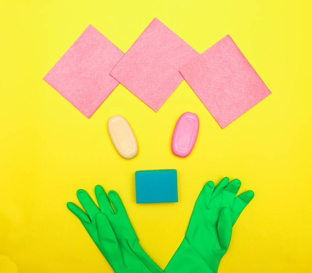 The concept of cleanliness and hygiene. The face is lined with detergents, gloves, soap and sponges. Disinfection. Space for text, flat lay. - Foto, Bild
