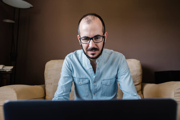 Portrait d'un homme de 35 ans utilisant un ordinateur portable à la maison
 - Photo, image