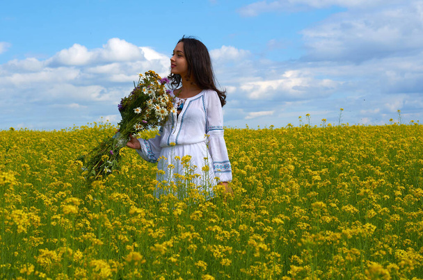 花の畑に白いドレスを着た若い女の子。畑に花が咲く夏の畑 - 写真・画像