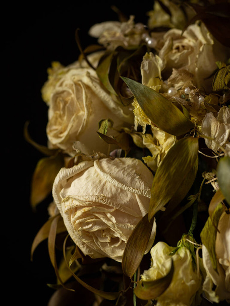 Wilted white roses in a vase in the dimness of the room - Foto, imagen