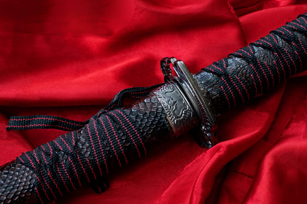 Samurai sword on the red cloth close up - Foto, afbeelding