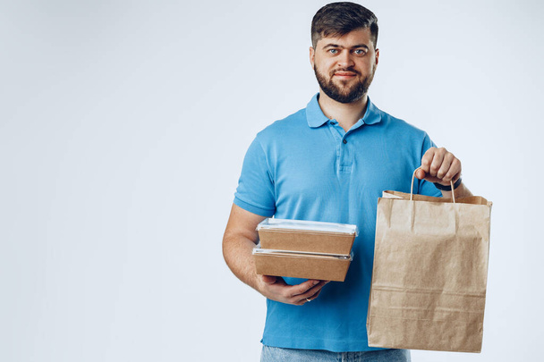 Food delivery courier with order on grey background - Photo, Image