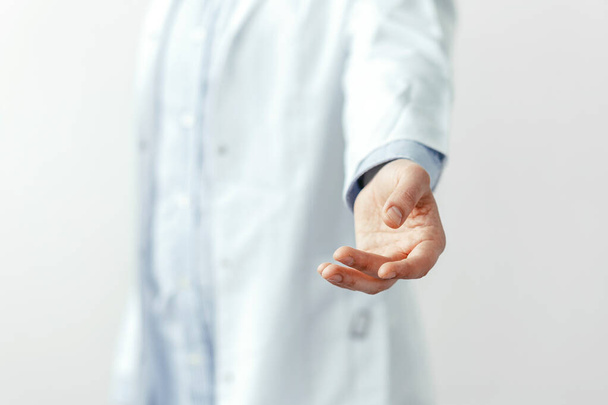 Male doctor offering helping hand closeup. Doctor on blurred background giving empty hands. Friendly and cheerful gesture. Medical cure and tests advertisement concept. Physician ready to examine and save patient.  - Fotoğraf, Görsel