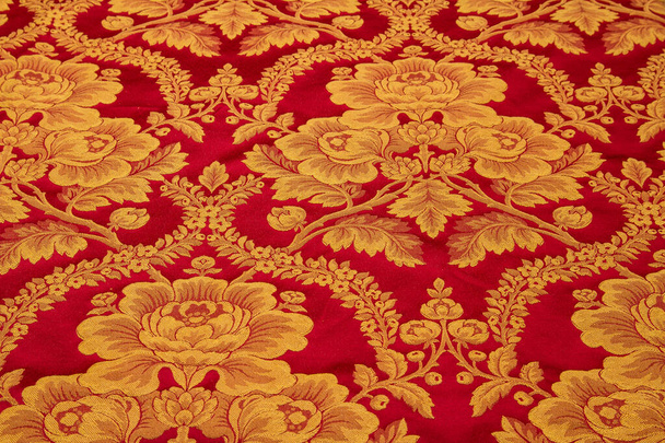 Parlak kırmızı kumaş üzerinde altın çiçek buketleri - Fotoğraf, Görsel