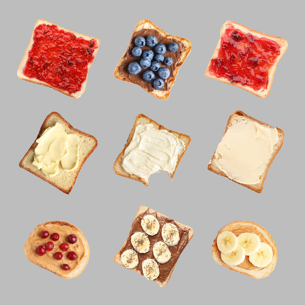 Set of delicious toasted bread with different toppings on grey background, top view - Fotografie, Obrázek