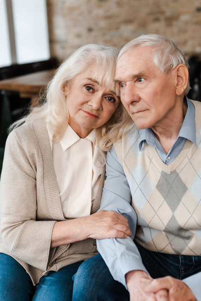 sad elderly wife and husband hugging and sitting at home on quarantine - Φωτογραφία, εικόνα