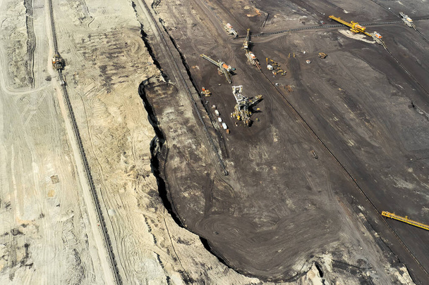 Pohled shora na důlní lom s obrovským vybavením pro těžbu uhlí nebo přírodních surovin. Fungující kolečkový bagr.  - Fotografie, Obrázek