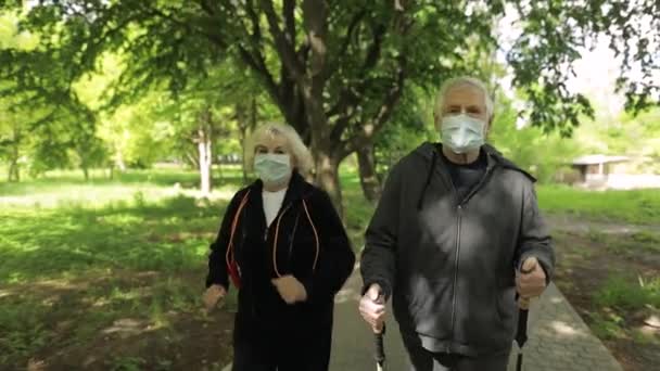 Aktywny starszy starzec, kobieta szkoląca nordic walking w parku podczas kwarantanny - Materiał filmowy, wideo