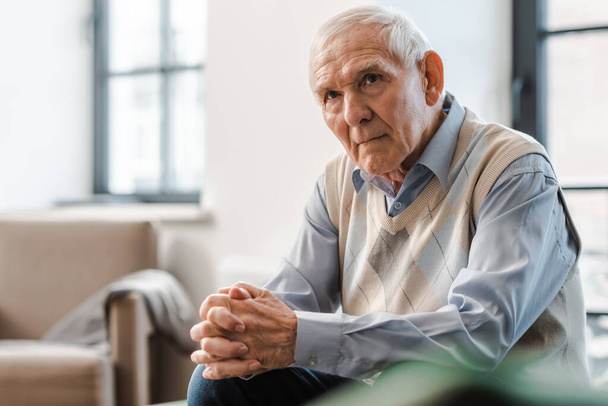 sad elderly man sitting alone on sofa during quarantine - Valokuva, kuva