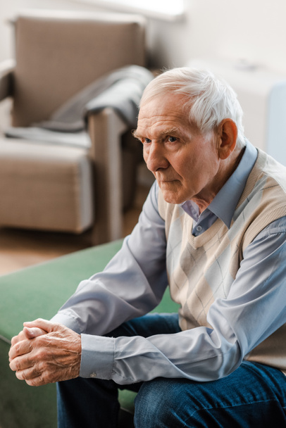 lonely elderly man sitting on sofa during quarantine - Foto, afbeelding