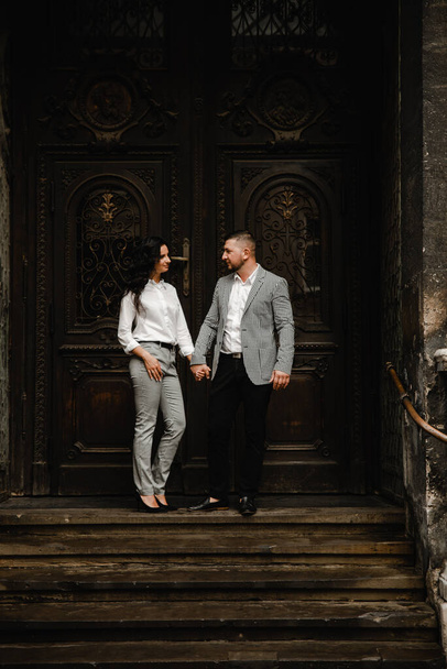 love story of a beautiful couple in love on the streets of the old city,lovers walk holding hands,happy young couple,man with woman cuddling,family look - 写真・画像