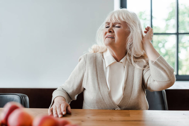 elderly woman having headache while sitting at home during quarantine - Photo, Image