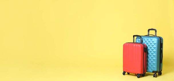 Stylish suitcases on yellow background, space for text. Banner design  - Фото, изображение