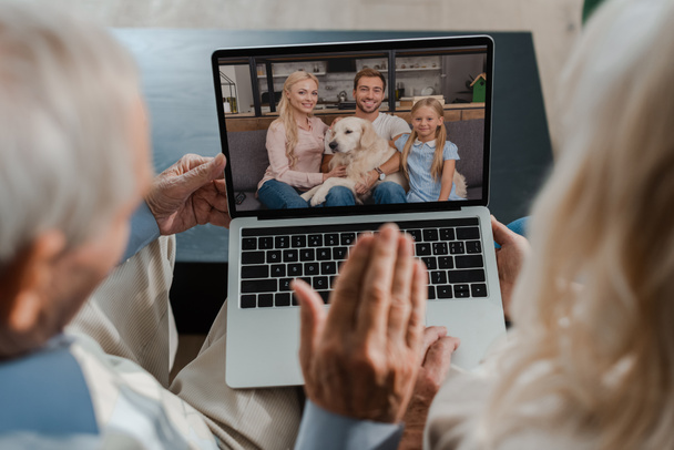 avós acenando enquanto conversam por vídeo com a família em quarentena
 - Foto, Imagem