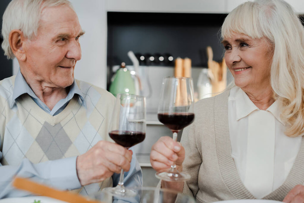 elderly couple drinking red wine at home on self isolation - Foto, Bild