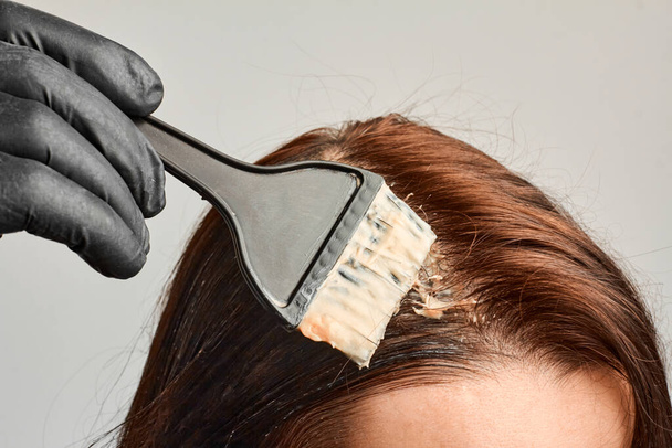 Primeros planos mujer manos teñir el cabello con un cepillo negro. Coloración del cabello blanco en casa
. - Foto, Imagen