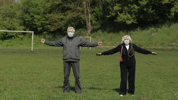Casal idoso activo. Homem e mulher fazem exercícios físicos de alongamento
 - Foto, Imagem
