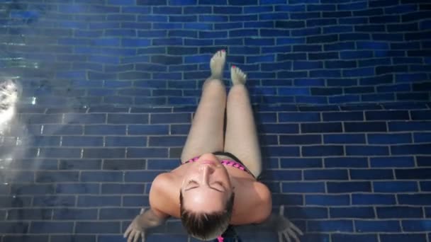 morena senta-se na água transparente da piscina do hotel
 - Filmagem, Vídeo