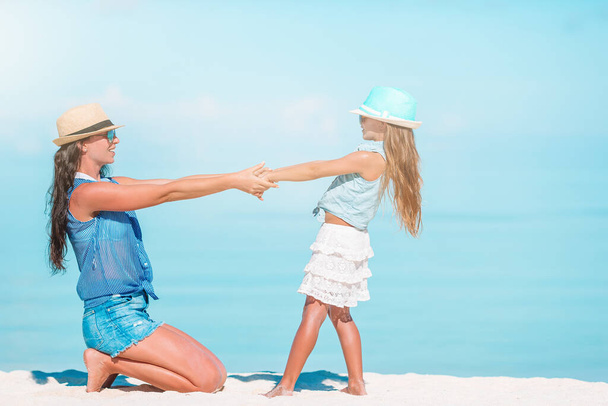 Beautiful mother and daughter at Caribbean beach enjoying summer vacation. - Zdjęcie, obraz