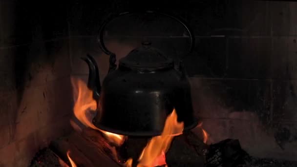 Alte Teekanne mit Wasser für die argentinische Mate über einem Holzfeuer. In Zeitlupe. - Filmmaterial, Video