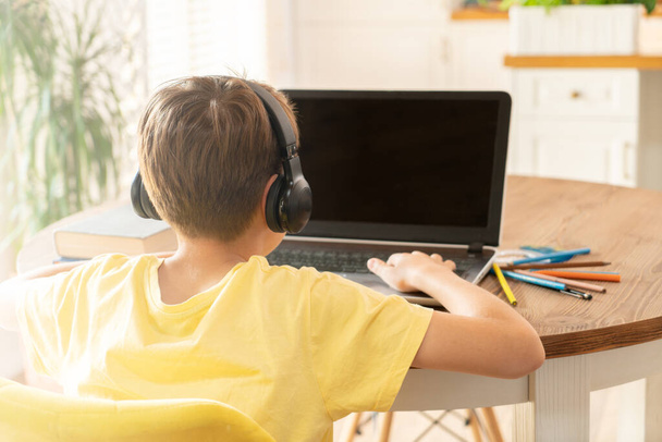 Boy child studying at home using laptop. Distance learning, online lesson, video conference, school lessons in electronic form. Modern school, technology, education, children concept. - 写真・画像