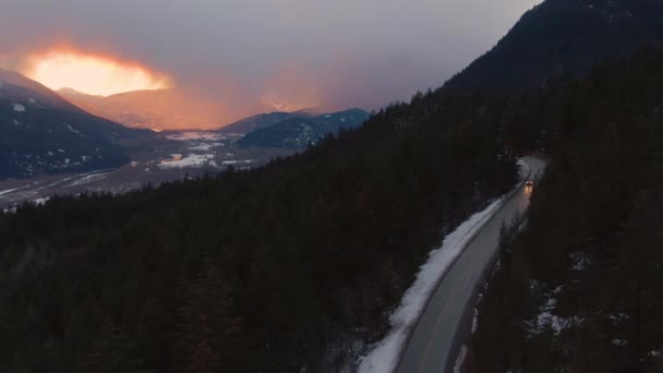 ДРОНЄ: Автомобілі їдуть вздовж автостради, перетинаючи сосновий ліс у сніговій Канаді.. - Кадри, відео