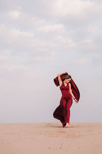 Girl in red dress at sunset in the desert - Foto, Imagen