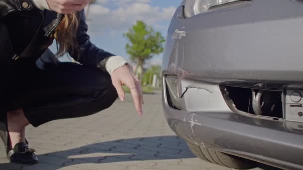 Young Cute Woman Making Phone Call After Traffic Accident. Young upset woman standing at broken car and calling for repair service or insurer. Roadside assistance concept. - Materiał filmowy, wideo