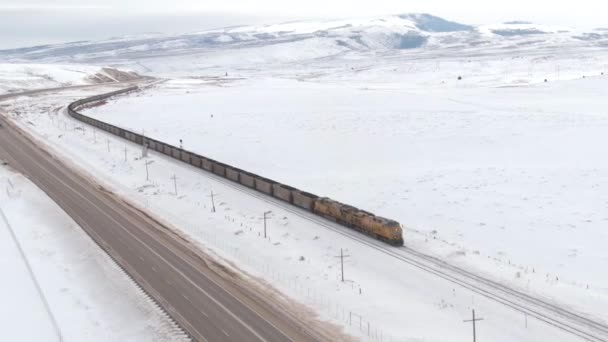 DRONE: Locomotive transports railcars full of coal across wintry United States - Footage, Video