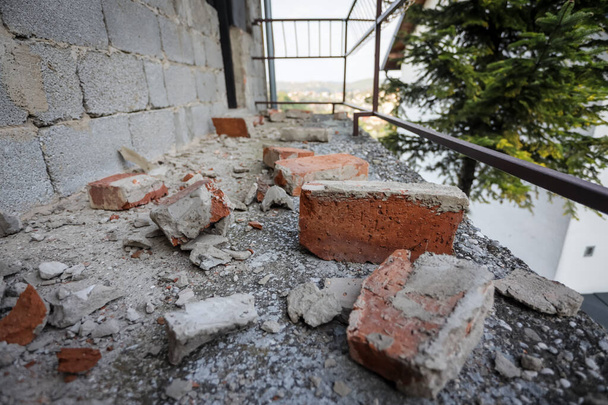1ヶ月前にクロアチアのザグレブでマグニチュード5.5の強い地震が発生した後、家のバルコニーの散乱と損傷を受けたレンガ - 写真・画像