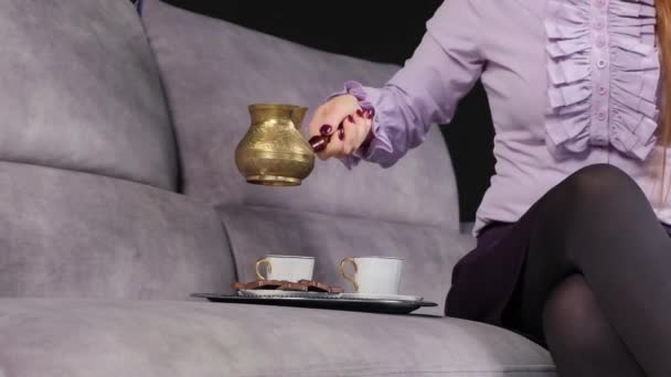ソファに座っている女がコーヒーを注ぐ - 映像、動画