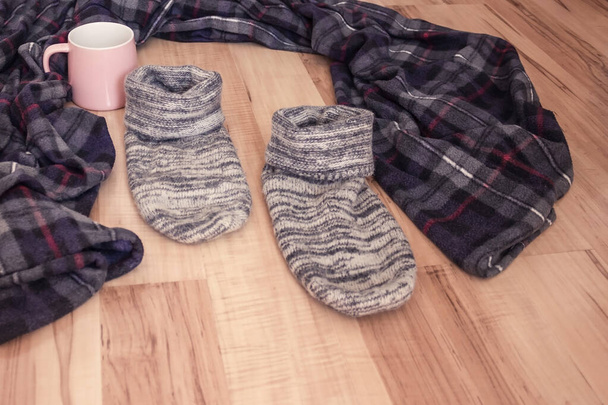 Leaving the house, changing the situation, personal growth. On the wooden floor was a cozy blanket, warm socks and a favorite mug. Leaving the father's house. - Photo, Image
