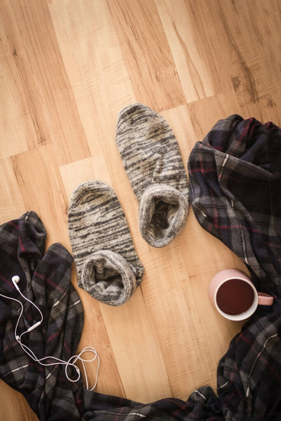 Light wooden background, plaid, woolen socks and a mug with tea. The owner is not there, he went in search of himself. Change of the situation, exit from the comfort zone. - Photo, Image