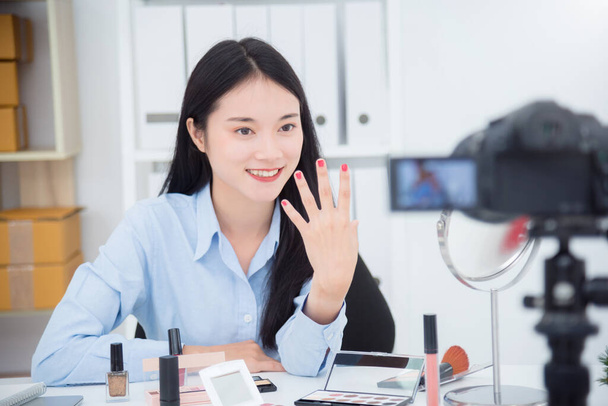 Schöne asiatische Mädchen zeigt ihre Nagelfarbe vor der Kamera zu Aufnahme Vlog Video Live-Streaming in ihrem Geschäft. - Foto, Bild