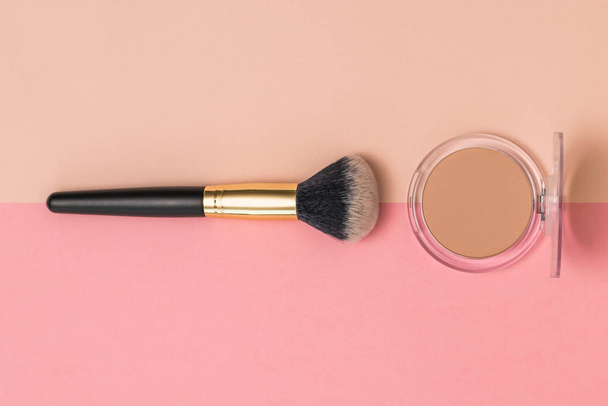 Soft makeup brush and a jar of face powder in beige and red background. - Fotografie, Obrázek