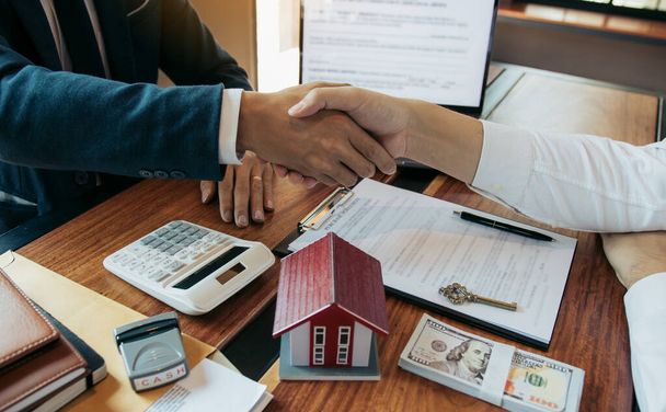 Home sales agents and buyers work on signing new homes and shaking hands. - Photo, Image