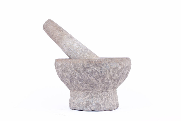 Гранітний кам "яний розчин і товкач - це інструмент для приготування їжі на білому фоні ізольованих продуктів.  - Фото, зображення
