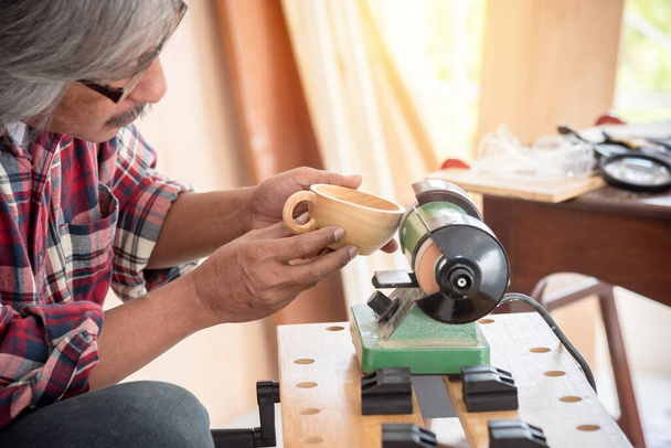 Senior Asian male carpenter working woodwork at carpentry shop - Photo, Image