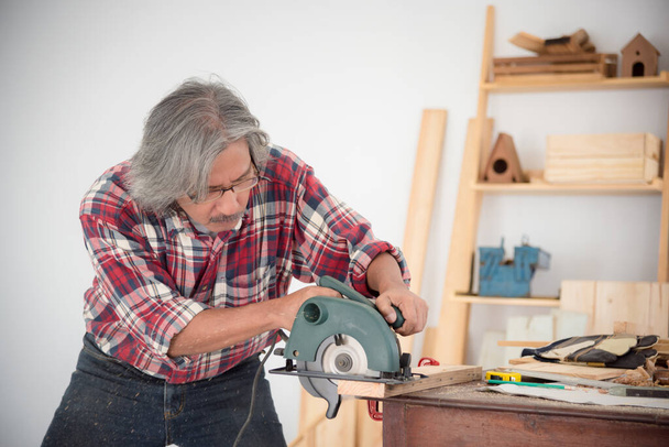 Senior Aziatische mannelijke timmerman houtwerk op timmerwerk winkel - Foto, afbeelding