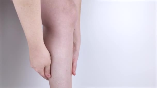 A woman suffers from pain in the calves. Stretching the calf muscle, varicose veins, leg cramps, or myositis. Orthopedic doctor examines patient - Footage, Video