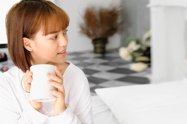 beautiful young asian woman drinking coffee in the morning at home - Foto, imagen